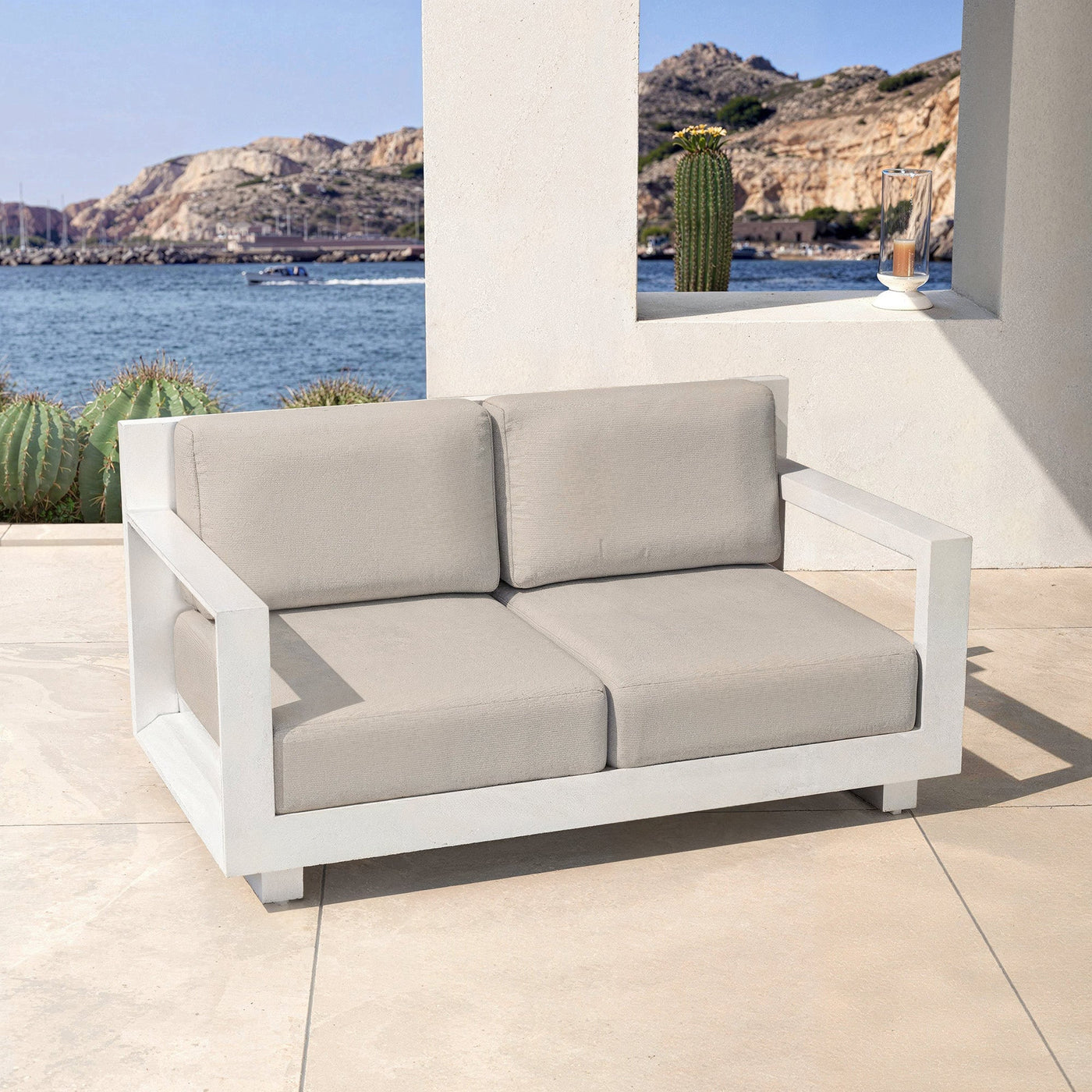 Canapé de jardin 2 places blanc Meublot Elba avec coussins confortables et structure en bois moderne.