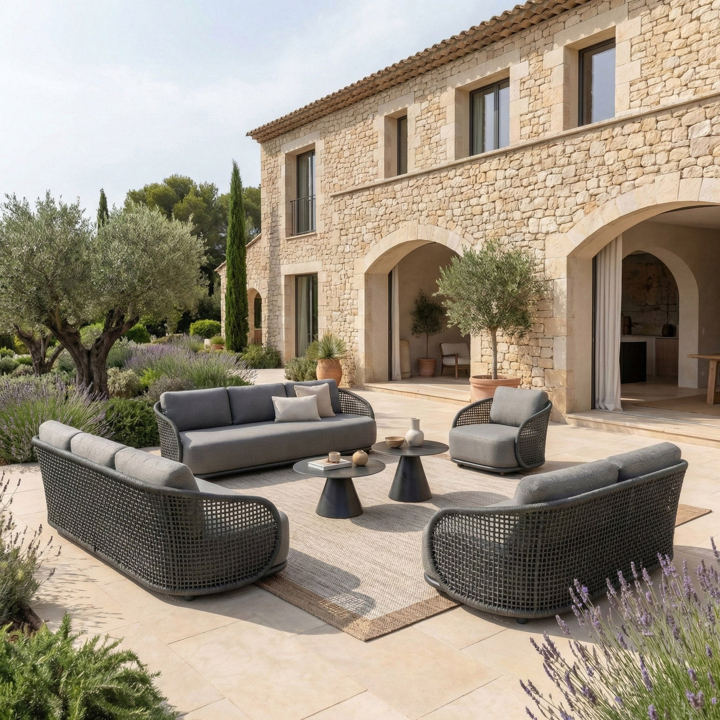 Canapé de jardin 2 places Riviera Meublot avec coussins gris anthracite, assises confortables, dans un salon de jardin extérieur.