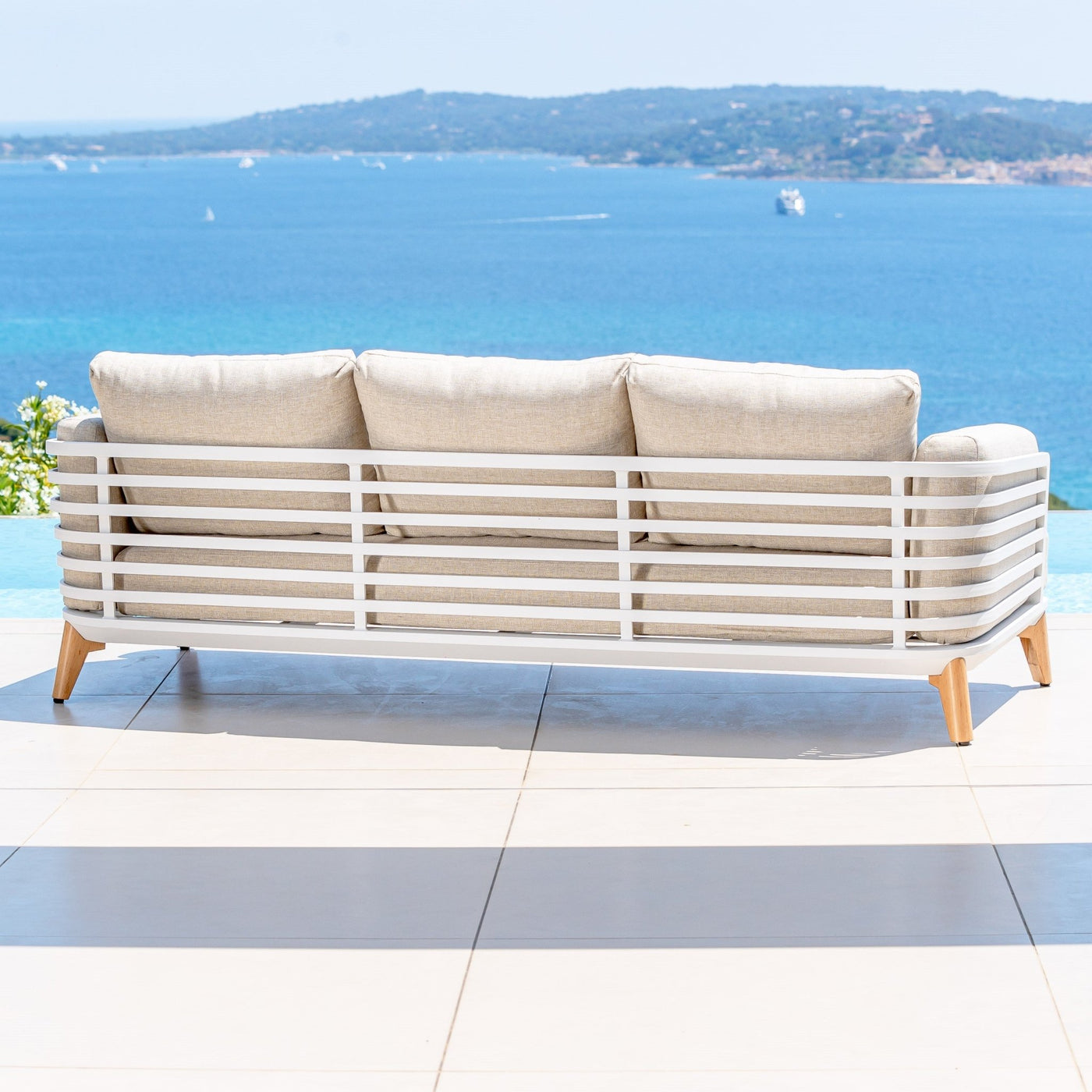 Canapé de jardin 3 places Meublot Monte Carlo avec coussins confortables en tissu gris clair.