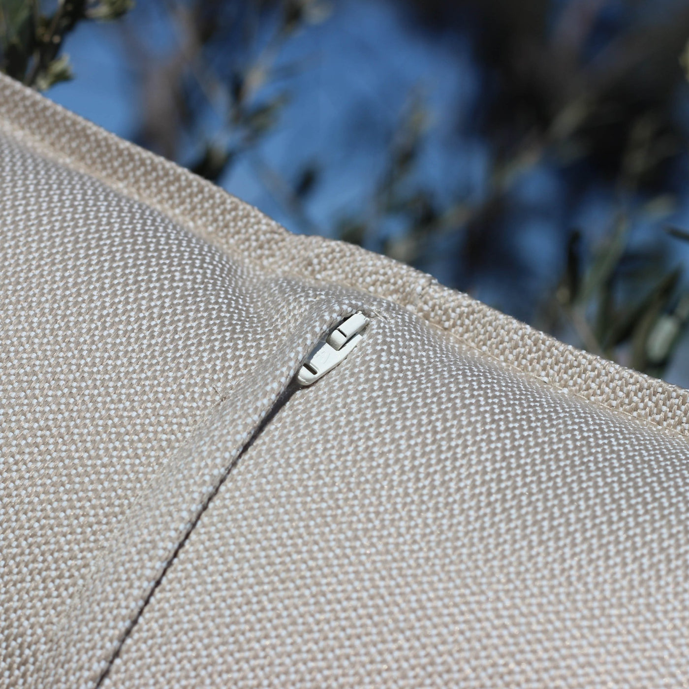 Coussin de décoration d'extérieur Kalena beige de 60x60 cm de la marque Meublot, avec fermeture éclair visible.