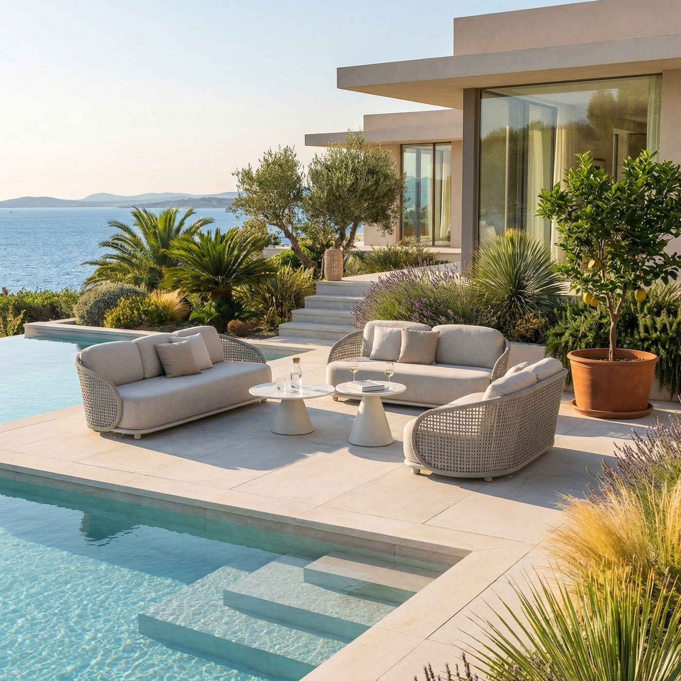 Fauteuil de jardin Riviera Meublot blanc avec coussins, idéal pour l’extérieur, visible dans un salon de jardin.