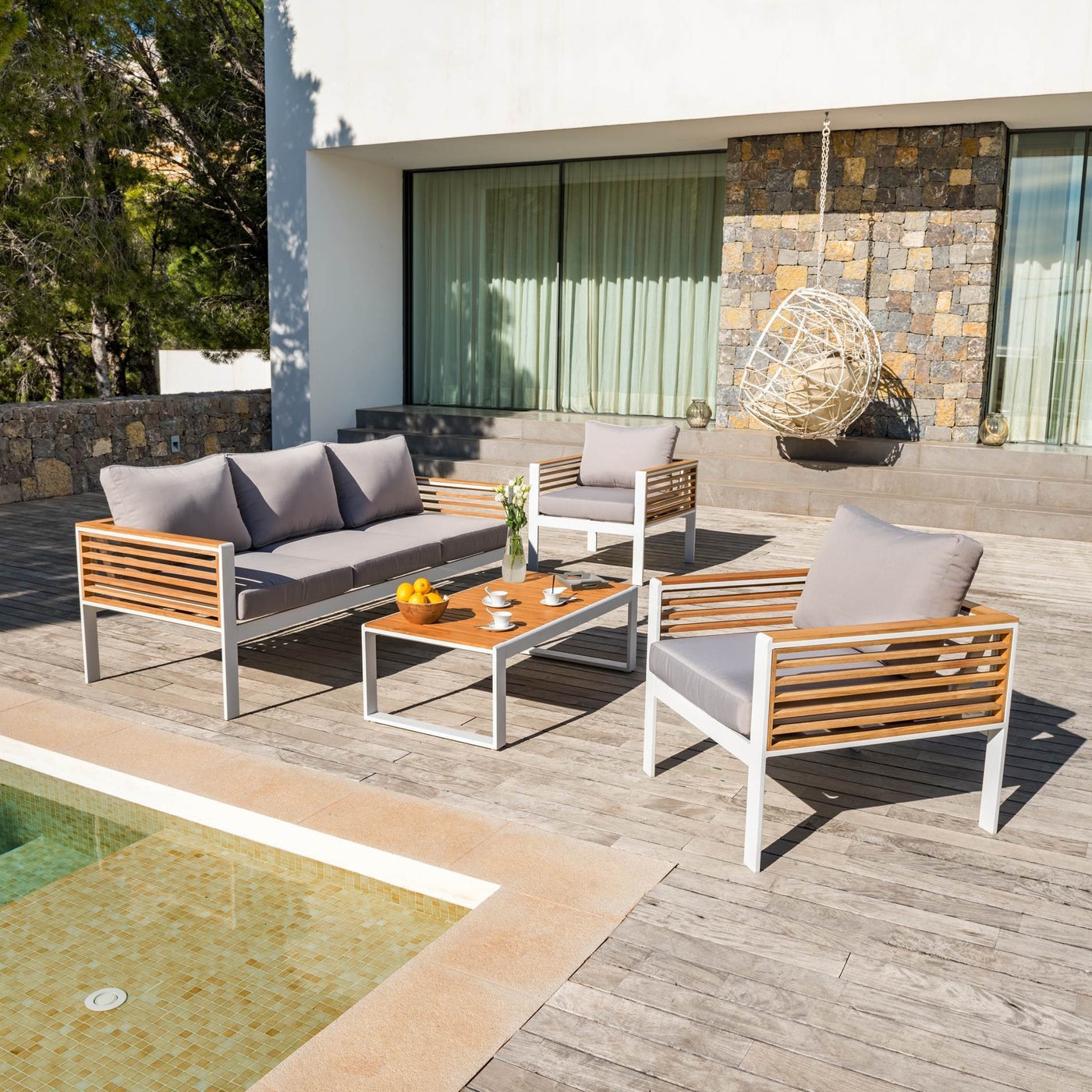 Salon de jardin Bali 5 places de la marque Meublot avec table et fauteuils en bois blanc dans un espace extérieur.