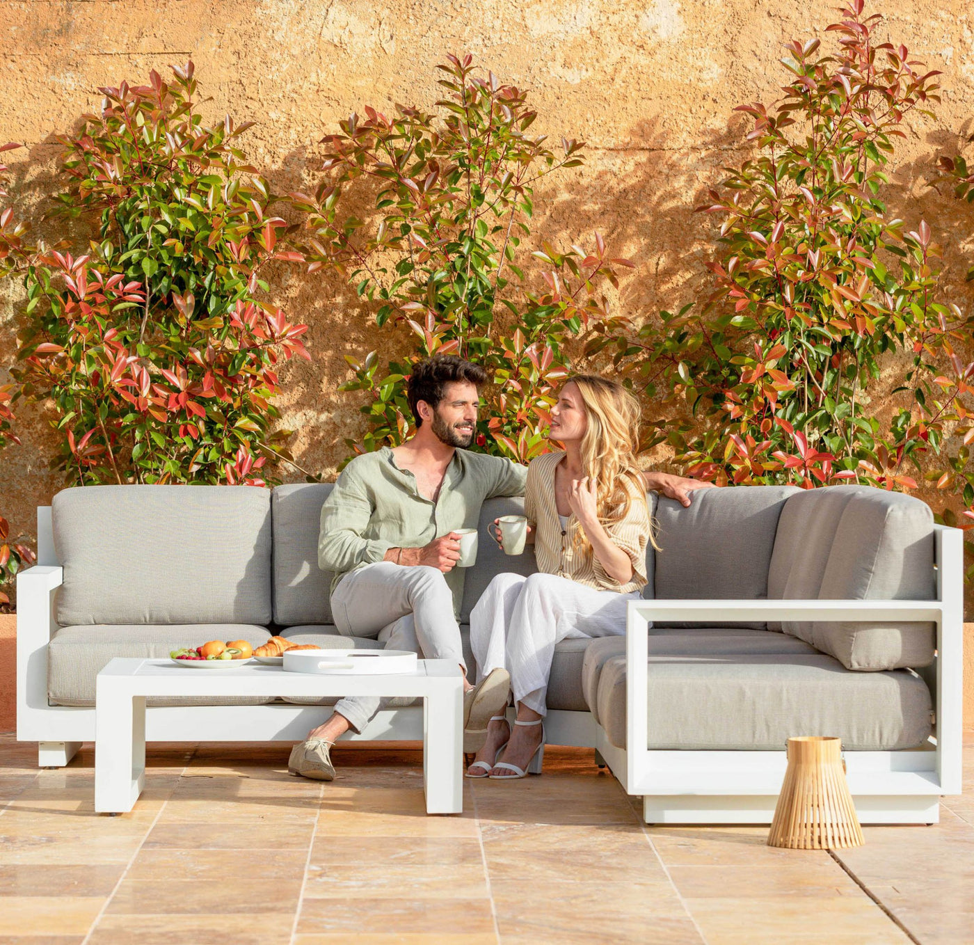 Salon de jardin d'angle Elba 5 places de Meublot, canapé en résine tressée blanc avec coussins confortables.