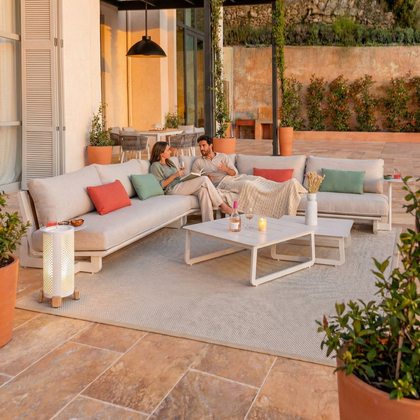 Salon de jardin d'angle Long Beach 5 places de la marque Meublot, avec coussins et table en bois dans un jardin extérieur.