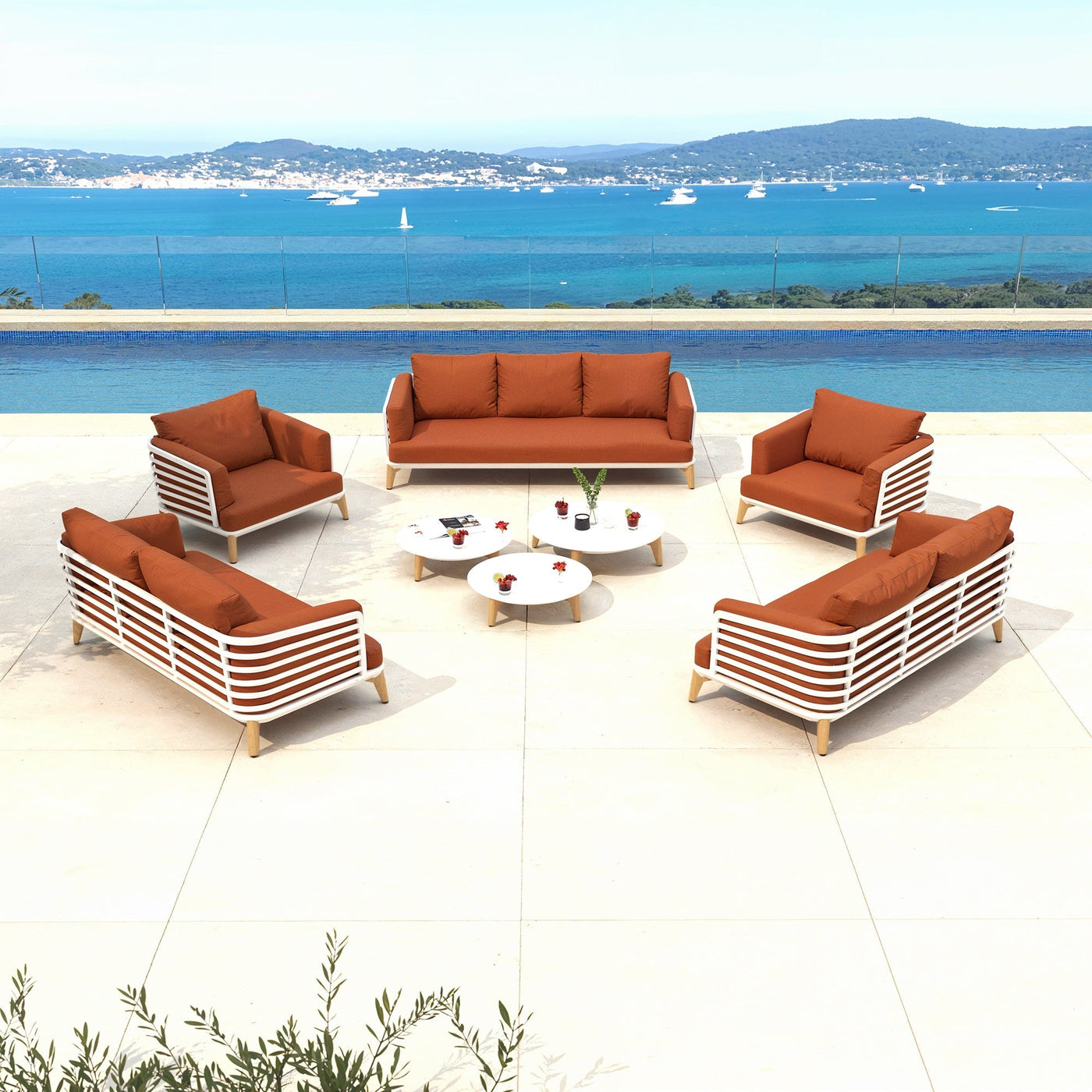 Salon de jardin Monte Carlo Meublot pour 9 personnes avec fauteuils et table en blanc et rouge, en extérieur.