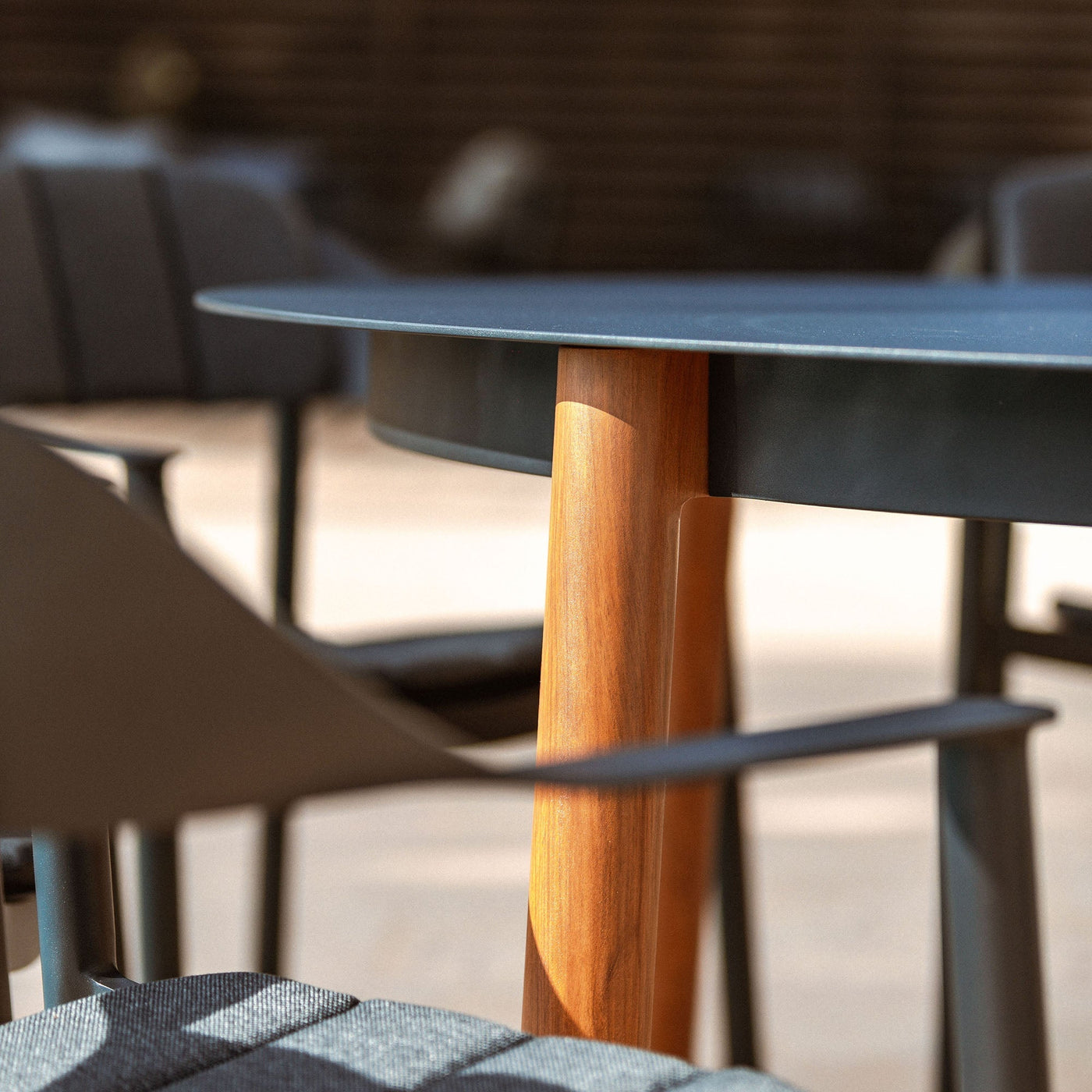 Table de jardin ronde 8 places Monte Carlo en aluminium gris anthracite, avec surface lisse et pieds solides.