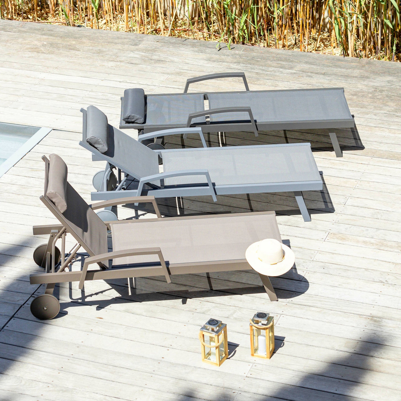 Transat Pirae Meublot en bois avec coussins colorés, conçu pour bains de soleil, vue en extérieur.