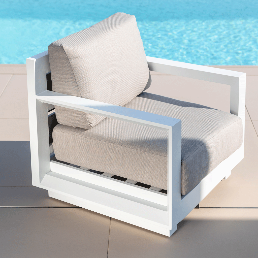 Fauteuil de jardin blanc Elba de la marque Meublot, avec cadre en métal et assise confortable en tissu, dans un espace extérieur.