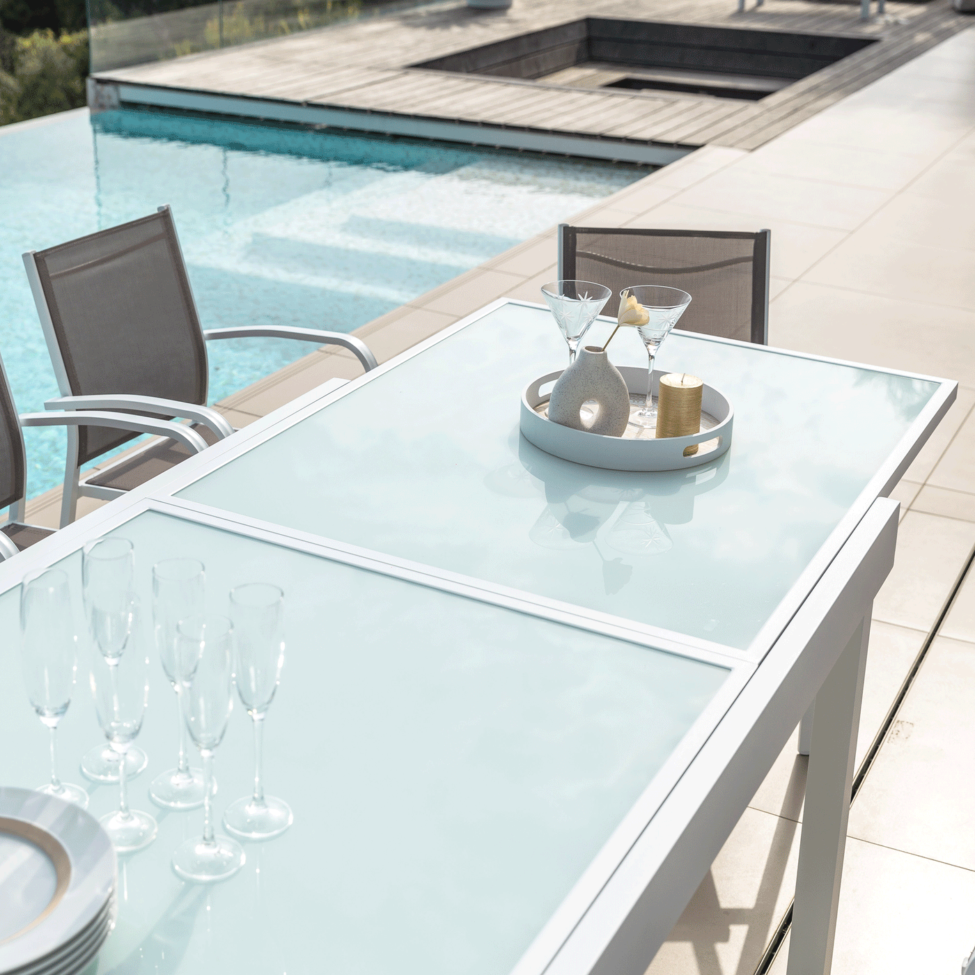 Table de jardin extensible Meublot avec plateau en verre Murano blanc, capacité 12 places, dimensions 320x100 cm.