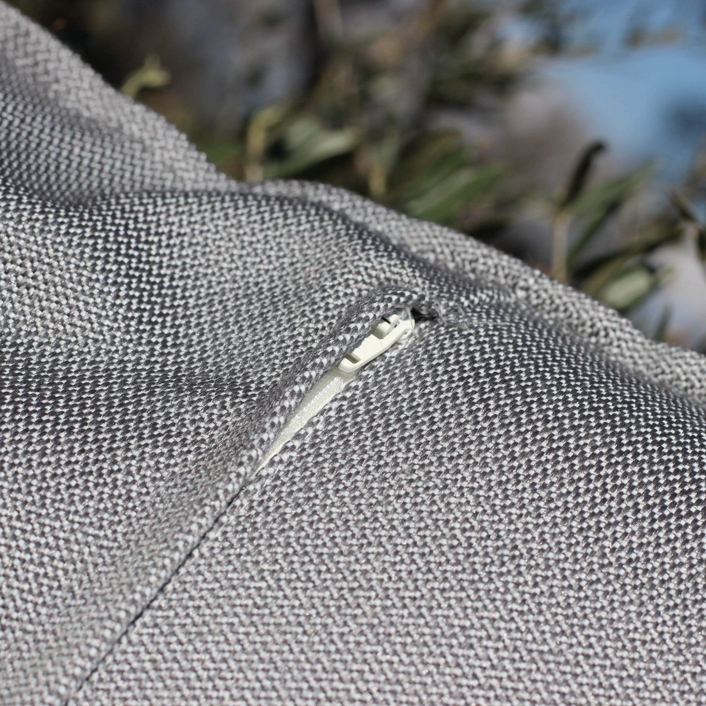 Coussin décoratif d'extérieur gris Borae de Meublot, 45x45 cm, avec fermeture à glissière visible.