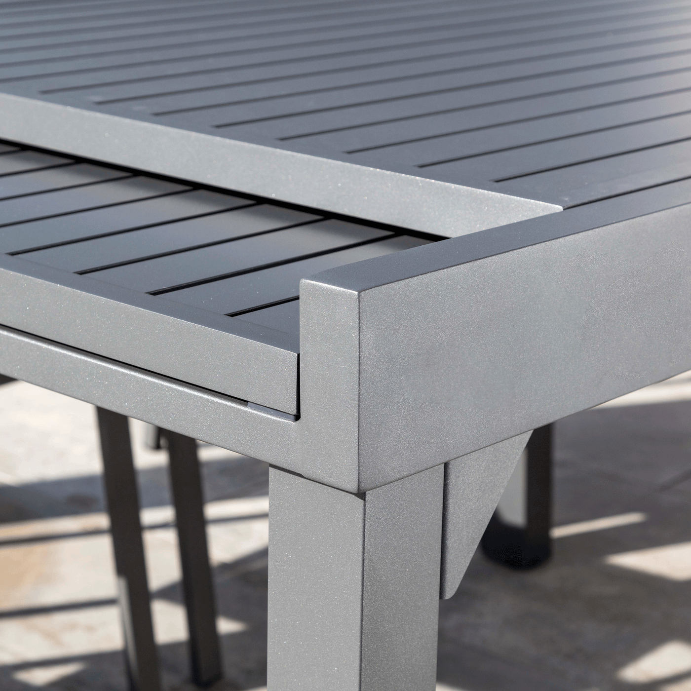 Table de jardin extensible Meublot Murano en aluminium anthracite, détails de la surface et de l'extension.