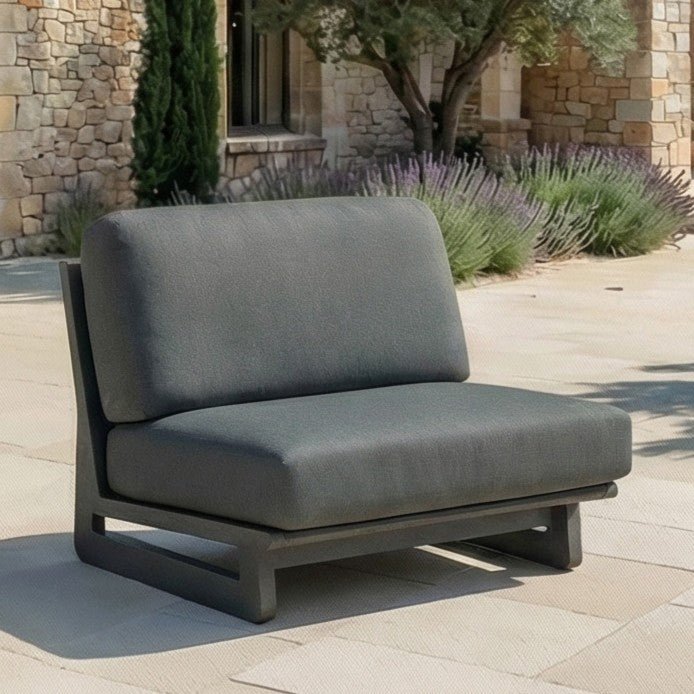 Salon de jardin d'angle Long Beach 6 places de la marque Meublot, avec coussins gris et table en bois dans un jardin extérieur.