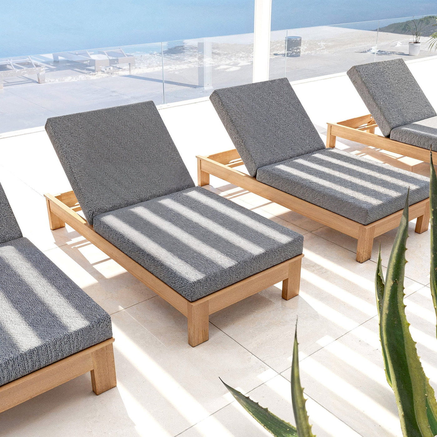 Transat Bornéo de Meublot, bain de soleil en bois avec coussin, dans un espace extérieur élégant et moderne.